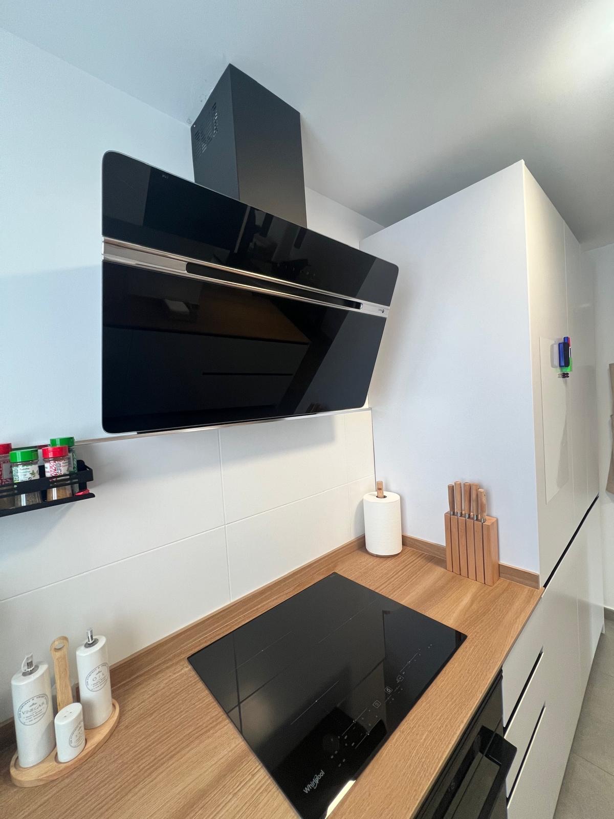Cocina blanca con península de madera y espacio comedor