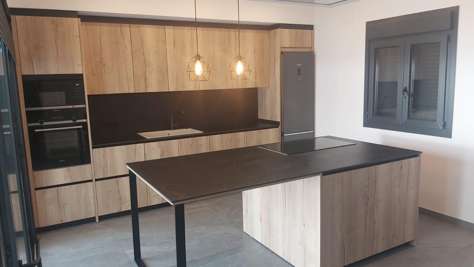 Cocina de roble con isla Dekton en Chiclana - vista angular