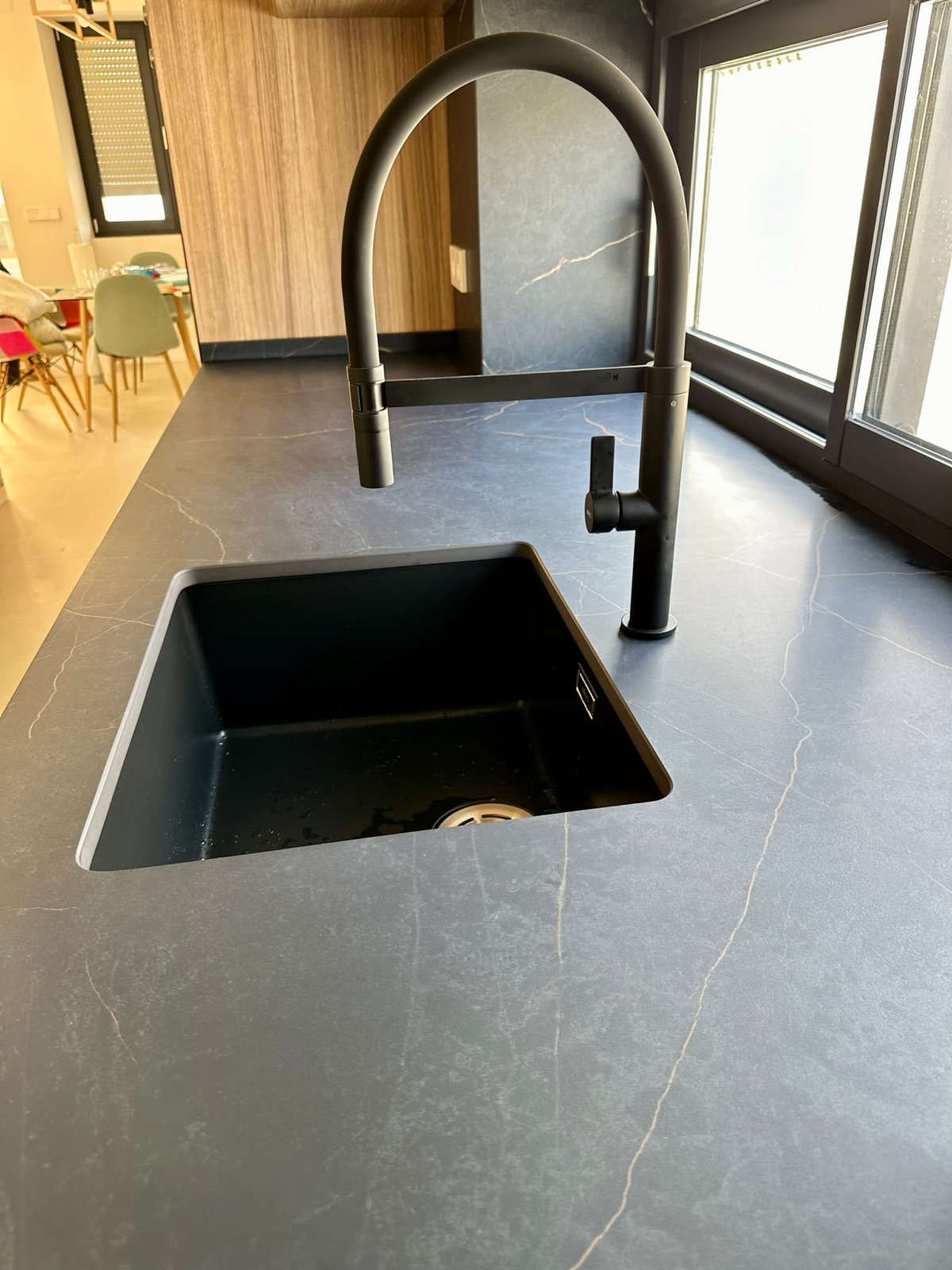 Detalle fregadero negro sobre encimera Dekton veteado