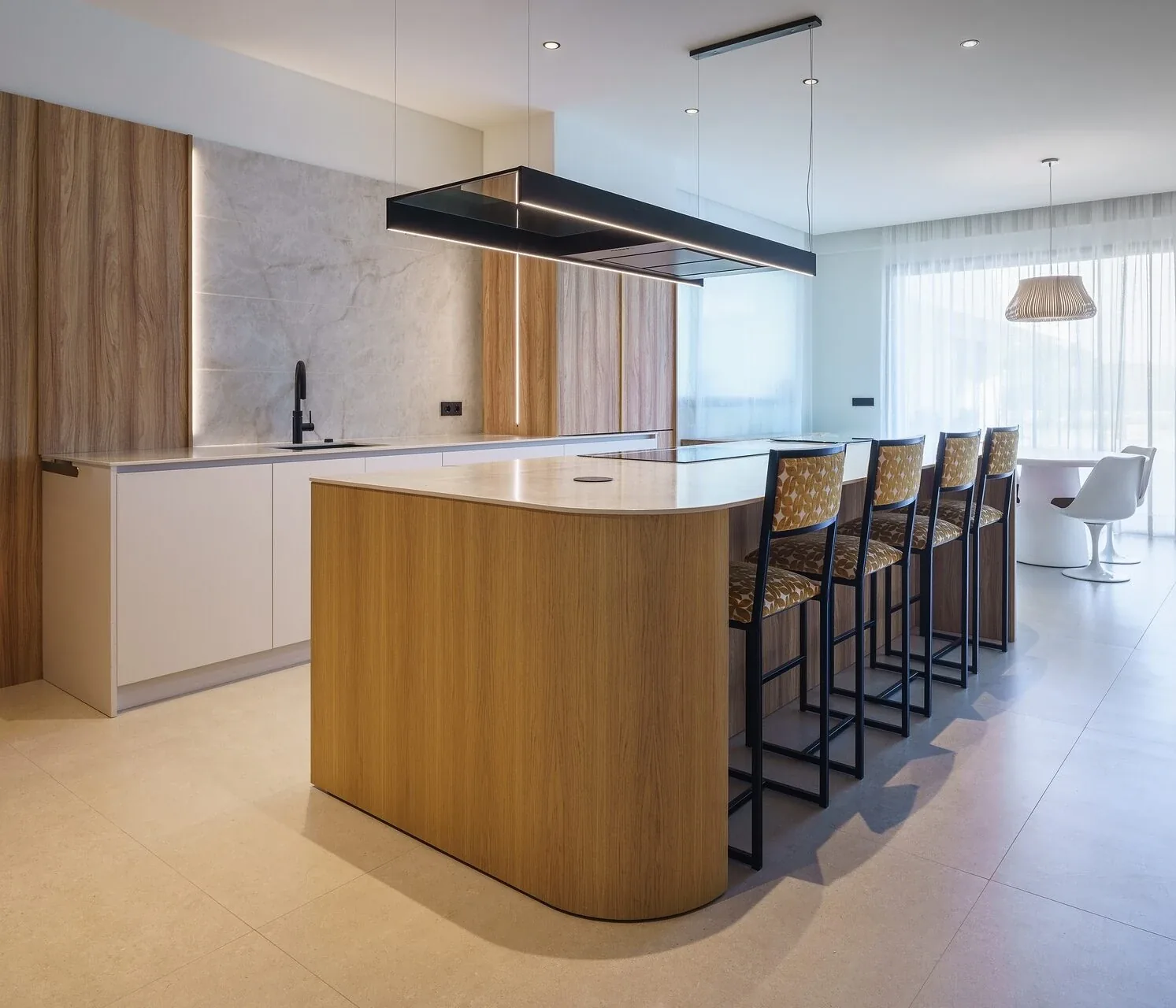Moderna con isla curva y acabados en madera natural — cocina a medida de Rosso Home Design en Chiclana de la Frontera