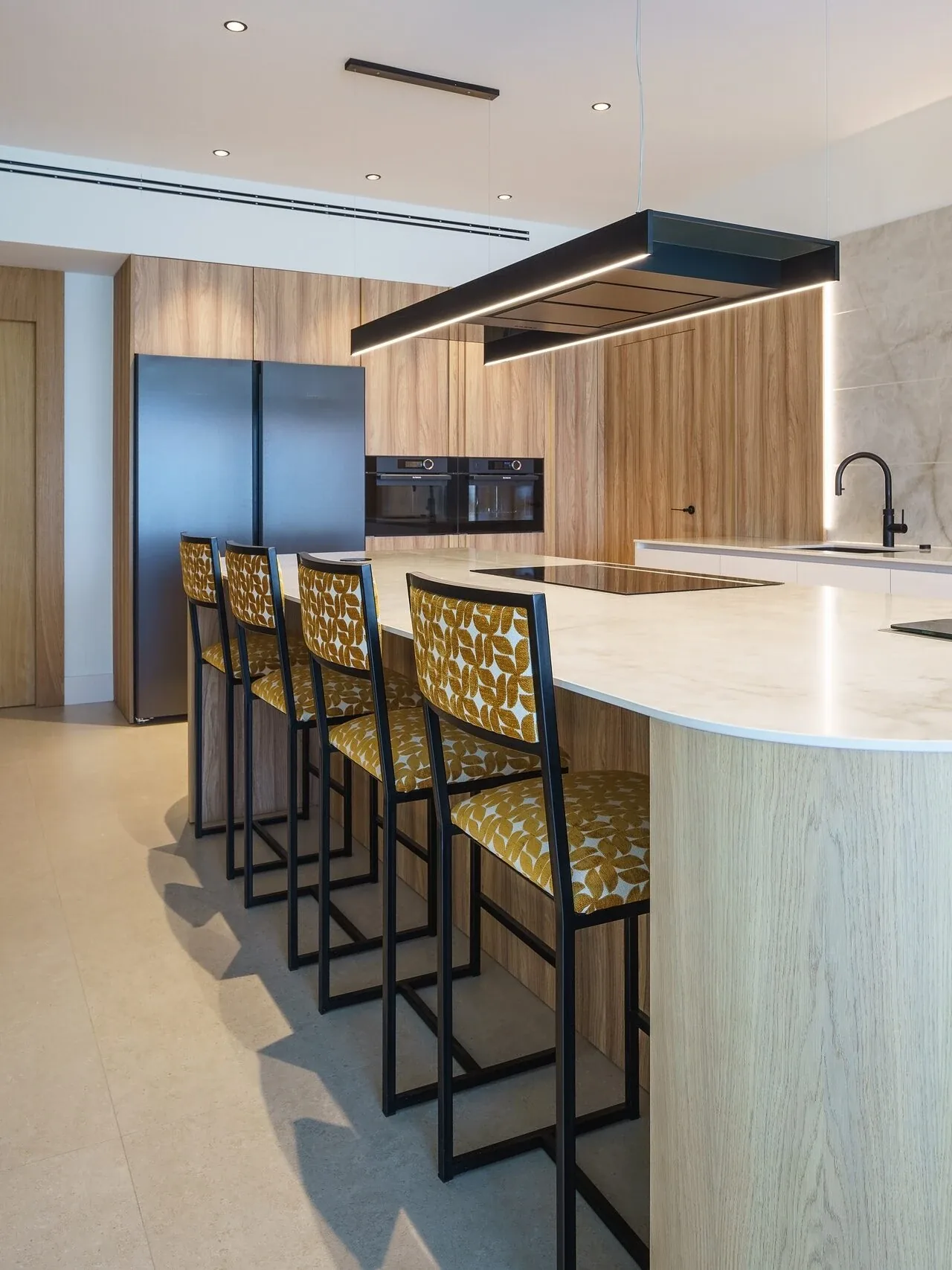 Moderna con isla curva y acabados en madera natural — cocina a medida de Rosso Home Design en Chiclana de la Frontera