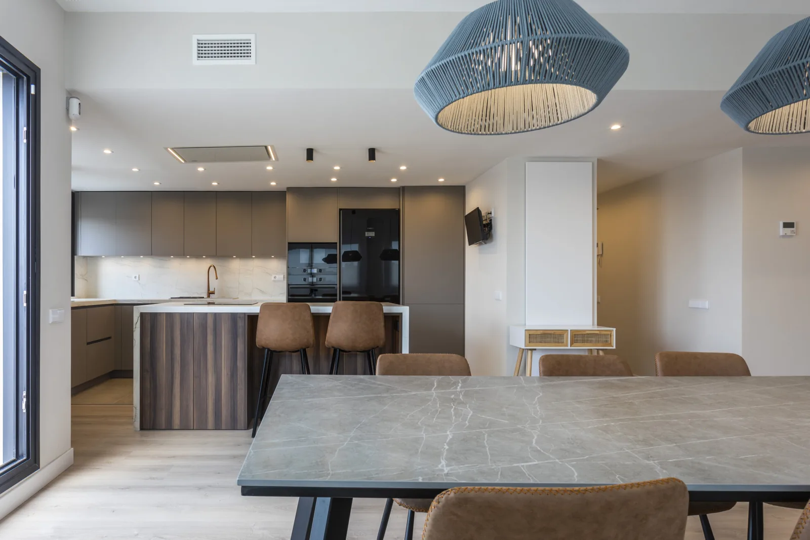 Moderna con isla diseno luz y materiales atemporales — cocina a medida de Rosso Home Design en Jerez de la Frontera