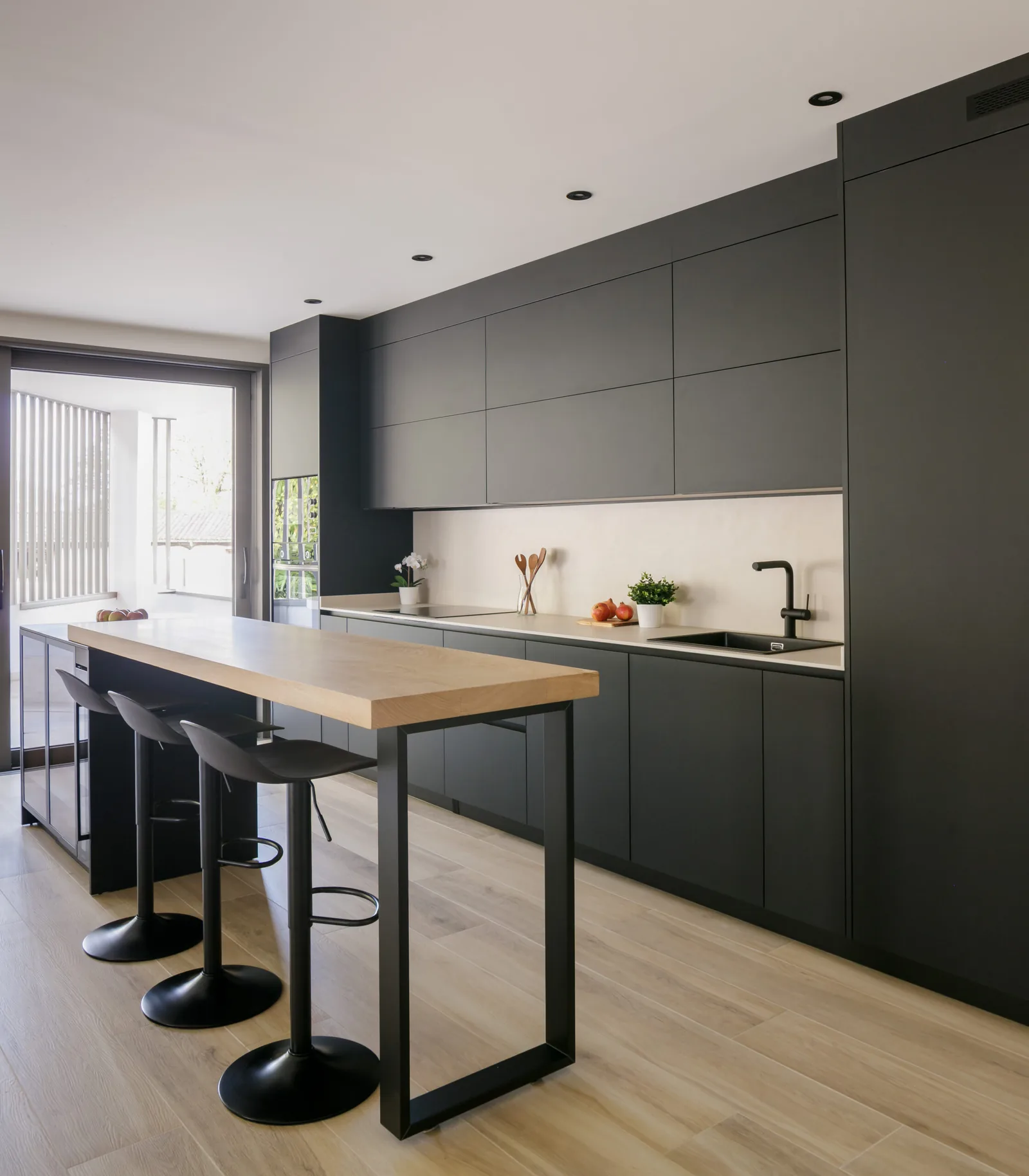 Moderna en paralelo con isla y acabados en negro mate — cocina a medida de Rosso Home Design en Cádiz