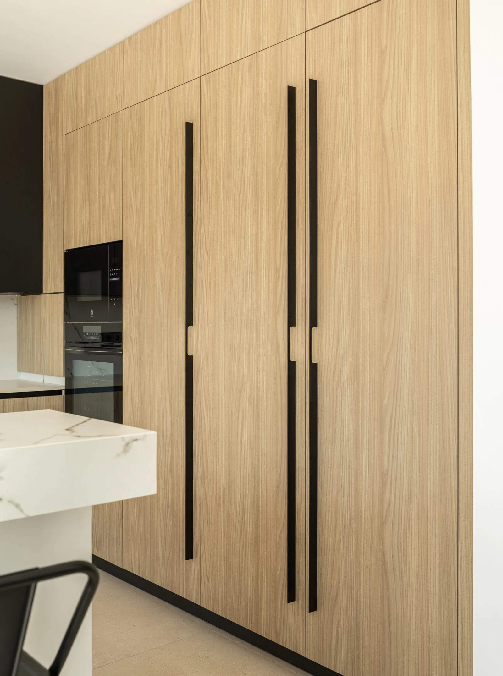 Moderna isla muebles hasta techo — cocina a medida de Rosso Home Design en Cádiz